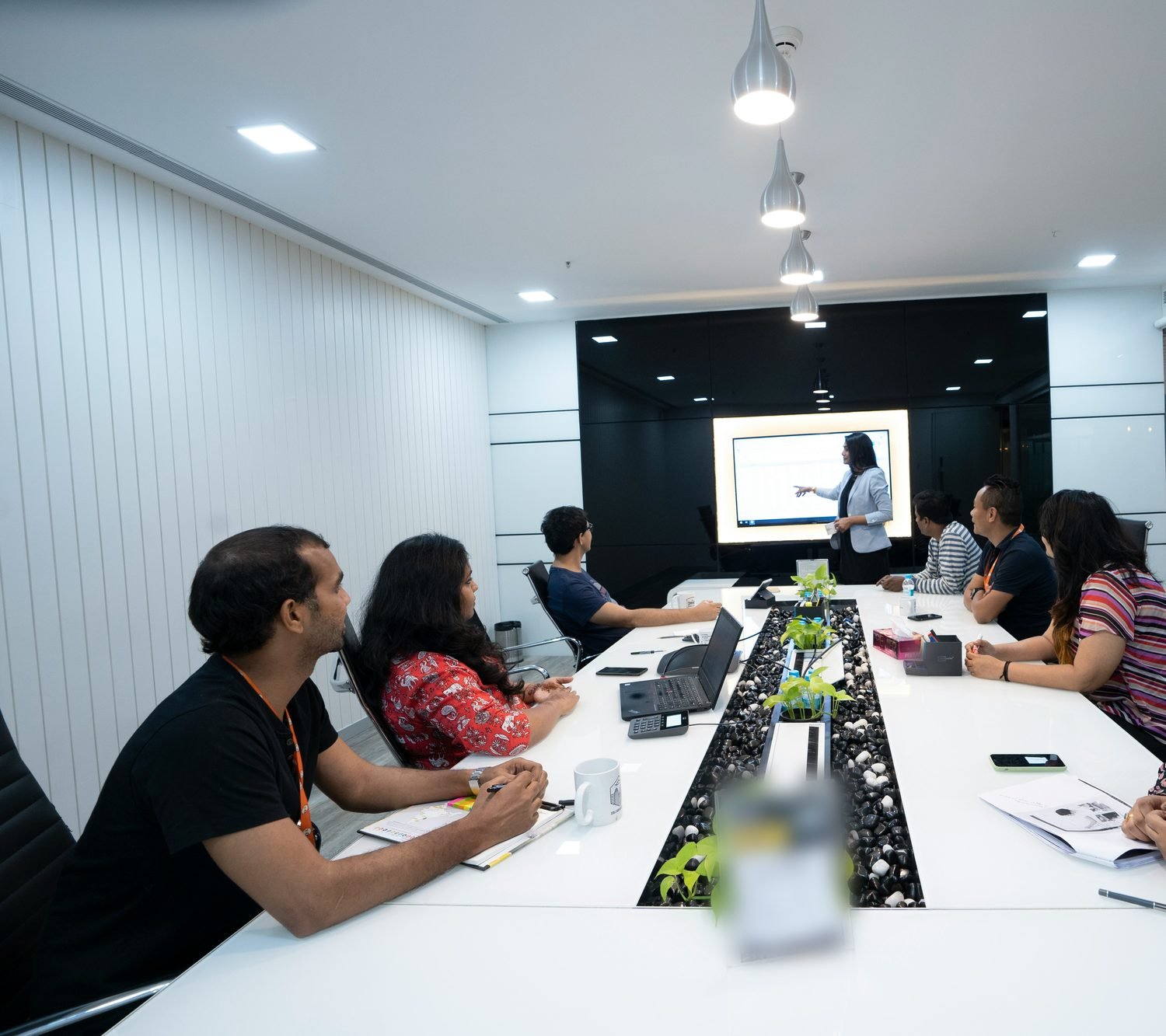 A team reviewing pipeline figures on a screen in a meeting room