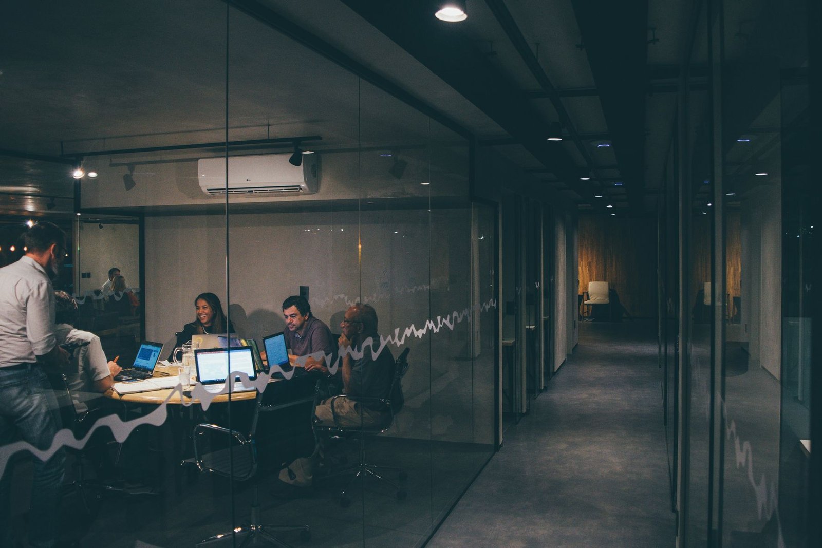A team meeting late in a glass-walled room