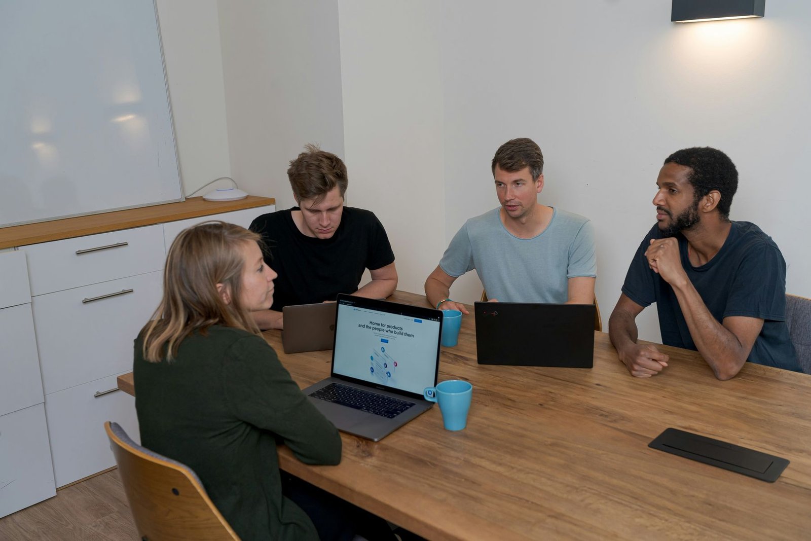 Four people discussing a product around a table